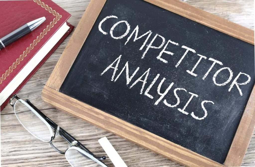 competitor analysis - chalkboard - glasses- book and a pen