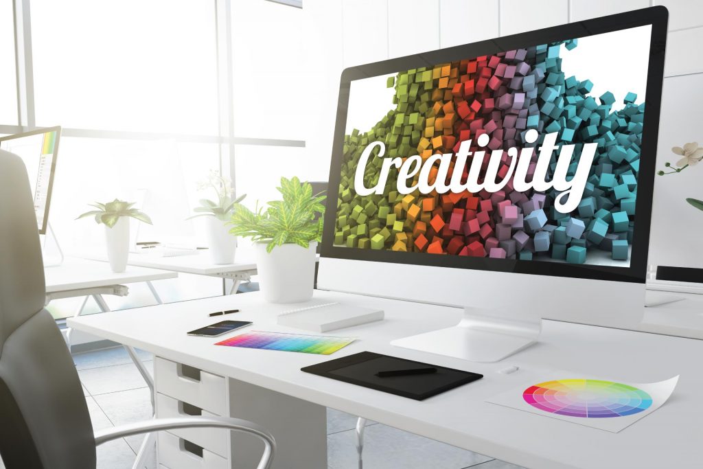 creativity written on the monitor screen - desktop setup - tablet - office - colors - creativity